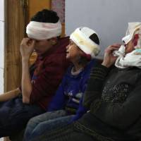 Wounded Syrians wait to receive treatment at a make-shift hospital in Kafr Batna following Syrian government bombardments on the besieged eastern Ghouta region on the outskirts of the capital Damascus on Wednesday. Syrian jets carried out more deadly raids as Western powers and aid agencies voiced alarm over the mounting death toll and spiraling humanitarian catastrophe. | AFP-JIJI
