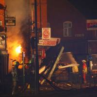 Members of the emergency services work at the site of an explosion that destroyed a convenience store and a home in Leicester, Britain, Sunday. | REUTERS