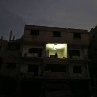 A man stands in a damaged building in Hamouria in the rebel-held enclave of Eastern Ghouta on Sunday. | AFP-JIJI