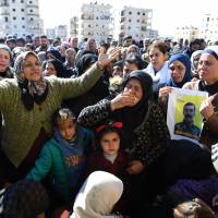 Syrian Kurds mourn in the northern town of Afrin during the funeral on Sunday of fighters from the People\'s Protection Units (YPG) militia and the Women\'s Protection Units (YPJ), killed in clashes in the Kurdish enclave in northern Syria on the border with Turkey. | AFP-JIJI