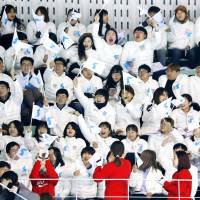 Spectators holding the Korean unification flag watch a preparatory ice hockey match between a unified Korean team and Sweden in Incheon, South Korea, on Sunday. | KYODO