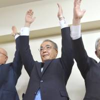 Hodo Nakamura (center) cheers in the city of Nagasaki after winning the Nagasaki gubernatorial election on Sunday night. | KYODO