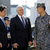 U.S. Vice President Mike Pence speaks with a Ground Self-Defense Force officer as he inspects PAC-3 missile interceptors with Defense Minister Itsunori Onodera at the Defense Ministry in Tokyo on Wednesday. | REUTERS