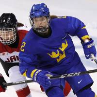 Aina Takeuchi of Japan  and Emmy Alasalmi of Sweden during a women\'s ice hockey classification match. | REUTERS