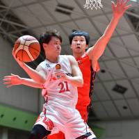 Diamond Dolphins guard Takaya Sasayama passes the ball as NeoPhoenix big man Atsuya Ota defends in the third quarter on Sunday in Toyohashi, Aichi Prefecture. Nagoya rallied to beat San-en 77-74. | B. LEAGUE