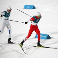 Japan\'s Akito Watabe (right) skis against Norway\'s Jarl Magnus Riiber in the Nordic combined men\'s large hill 10-km event at Alpsenia Cross-Country Skiing Centre on Tuesday night. Watabe finished fifth overall. | REUTERS
