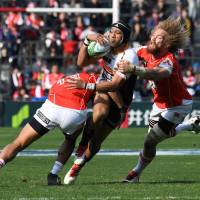 The Sunwolves\' Timothy Lafaele (left) and Willie Britz (right) tackle the Brumbies\' Christian Lealiifano on Saturday. | AFP-JIJI