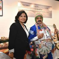 Angela Ayllon (left), charge d\'affaires of Bolivia, poses for a photo next to a man dressed as El Ekeko, a god of luck and prosperity, during the opening ceremony of an exhibition being held at the Cervantes Institute to mark the nomination of the ritual journeys in La Paz during Alasita to UNESCO\'s Intangible Cultural Heritage list. | YOSHIAKI MIURA
