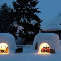 Children on Wednesday warm themselves inside kamakura (snow huts) in the city of Yokote, Akita Prefecture. About 100 of the huts have been constructed in different locations in the city for the two-day kamakura festival, which will end Friday. | KYODO