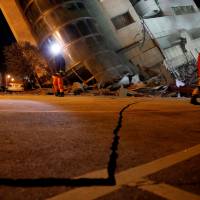 Rescue personnel search in Hualien, Taiwan, early Wednesday after a magnitude 6.4 earthquake brought deaths, with well over a hundred people still missing, and hundreds of injuries. | REUTERS