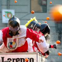 Participants fling oranges at rival teams on Sunday during the Battle of the Oranges, a boisterous annual festival in the northern Italian town of Ivrea. | REUTERS