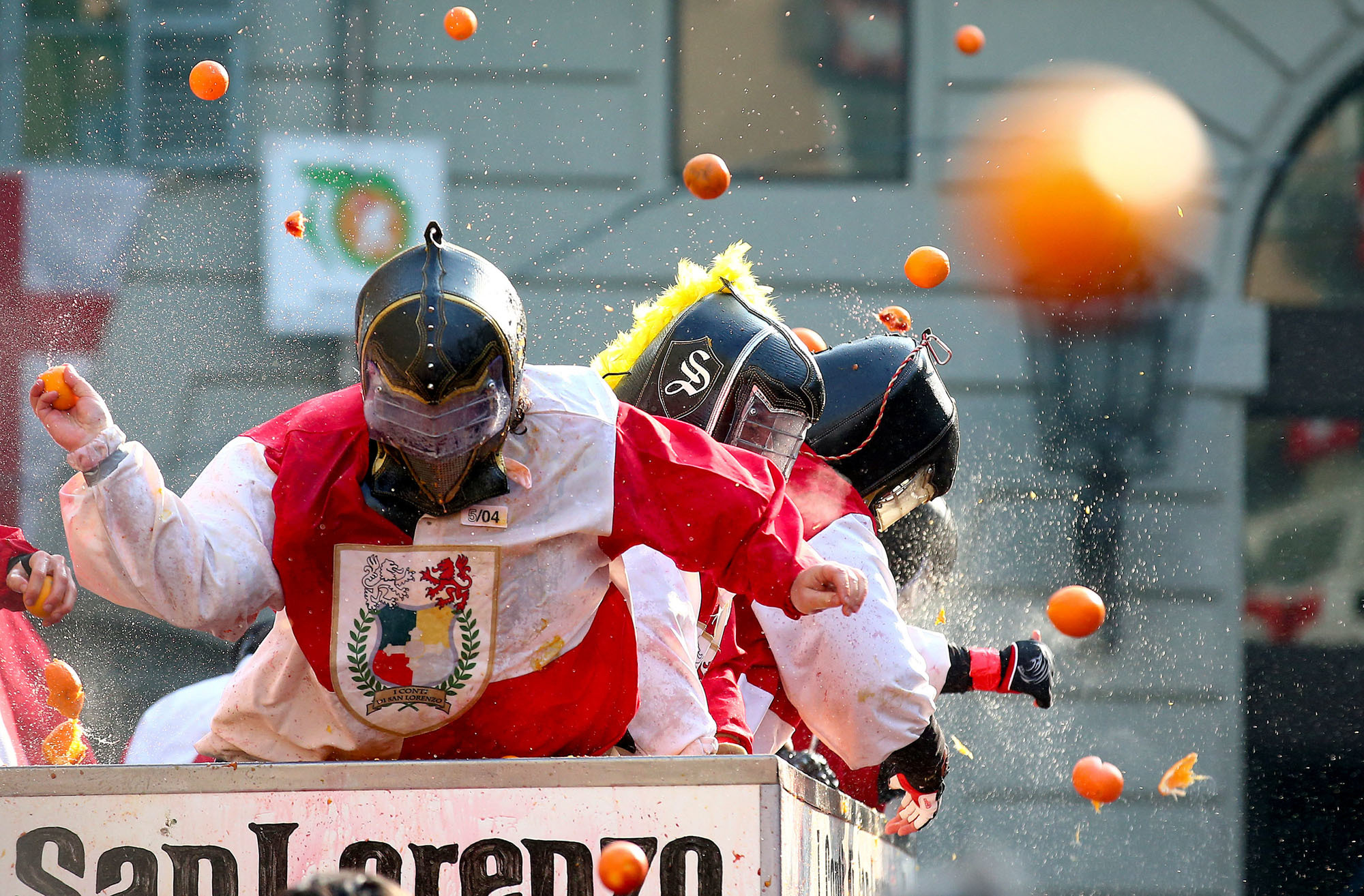 Participants fling oranges at rival teams on Sunday during the Battle of the Oranges, a boisterous annual festival in the northern Italian town of Ivrea. | REUTERS
