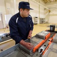 A 4R Energy Corp. employee checks a used lithium-ion electric vehicle battery during a demonstration at a 4R Energy Corp. factory in Namie, Fukushima Prefecture, during a media tour on Monday. | BLOOMBERG
