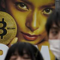 A huge advertisement for bitcoin is displayed near Shibuya Station in Tokyo. The major cryptocurrency dropped as much as 10 percent Thursday, pushing it toward the &#36;7,000 mark. | AP