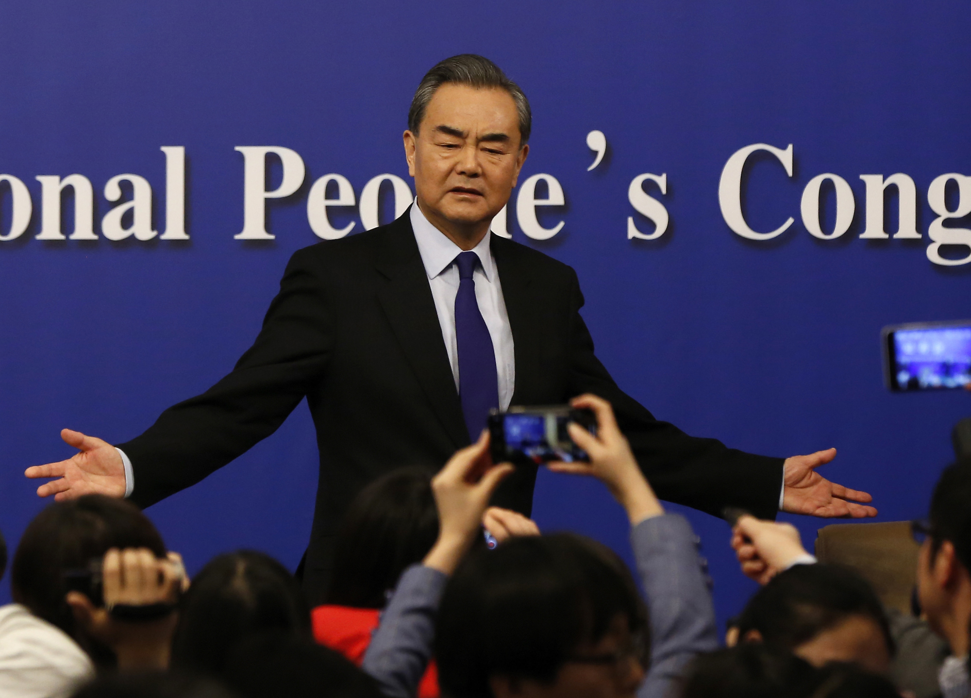 Chinese Foreign Minister Wang Yi gestures to journalists at a news conference on the sidelines of the National People's Congress at the media center in Beijing on March 8. Wang appeared to blame the U.S. and its allies for stirring up trouble in the South China Sea, which is claimed in all or in part by China and five other governments. | AP