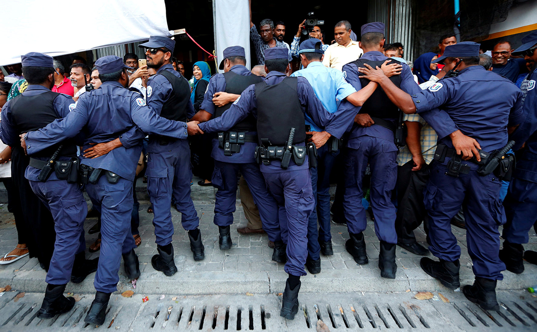 Maldivian Police officers push back opposition supporters near the main opposition Maldives Democratic Party (MDP) headquarters during a protest demanding the government to release jailed opposition leaders, including former Presidents Mohamed Nasheed and Maumoon Abdul Gayoom, in line with a Supreme Court order, in Male, Maldives, on February 9, 2018. | REUTERS
