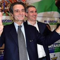 Attilio Fontana, candidate for the presidency of the Lombardia Region, makes the victory sign in his electoral campaign headquarters in Milan, Italy, Monday. In January, Fontana told Radio Padania, the mouthpiece of his anti-migrant League party, that being unwilling to \"accept all\" immigrants isn\'t \"xenophobic or racist,\" but logical. He said Italy needs to decide \"if our white race, our society, must continue to exist or be canceled out.\" | DANIEL DAL ZENNARO / ANSA / VIA AP