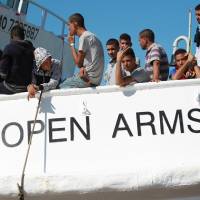 Migrants stand on the deck of the Spanish NGO\'s Proactiva Open Arms vessel at harbor at Porto Empedocle in the southern Italian island of Sicily last July. | MONTANA / ANSA / VIA AP