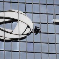 French urban climber Alain Robert, also known as \"French Spiderman,\" climbs the building of French energy group Total, at La Defense business center, in Paris Wednesday. | AP
