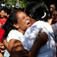 Relatives of inmates held at the General Command of the Carabobo Police react as they wait outside the prison, where a fire occurred in the cells area, according to local media, in Valencia, Venezuela, Wednesday. | REUTERS