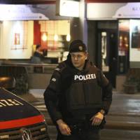 A police officer stands in front of a Japanese restaurant after several people were wounded in a knife attack on the streets of Vienna Wednesday. | AP