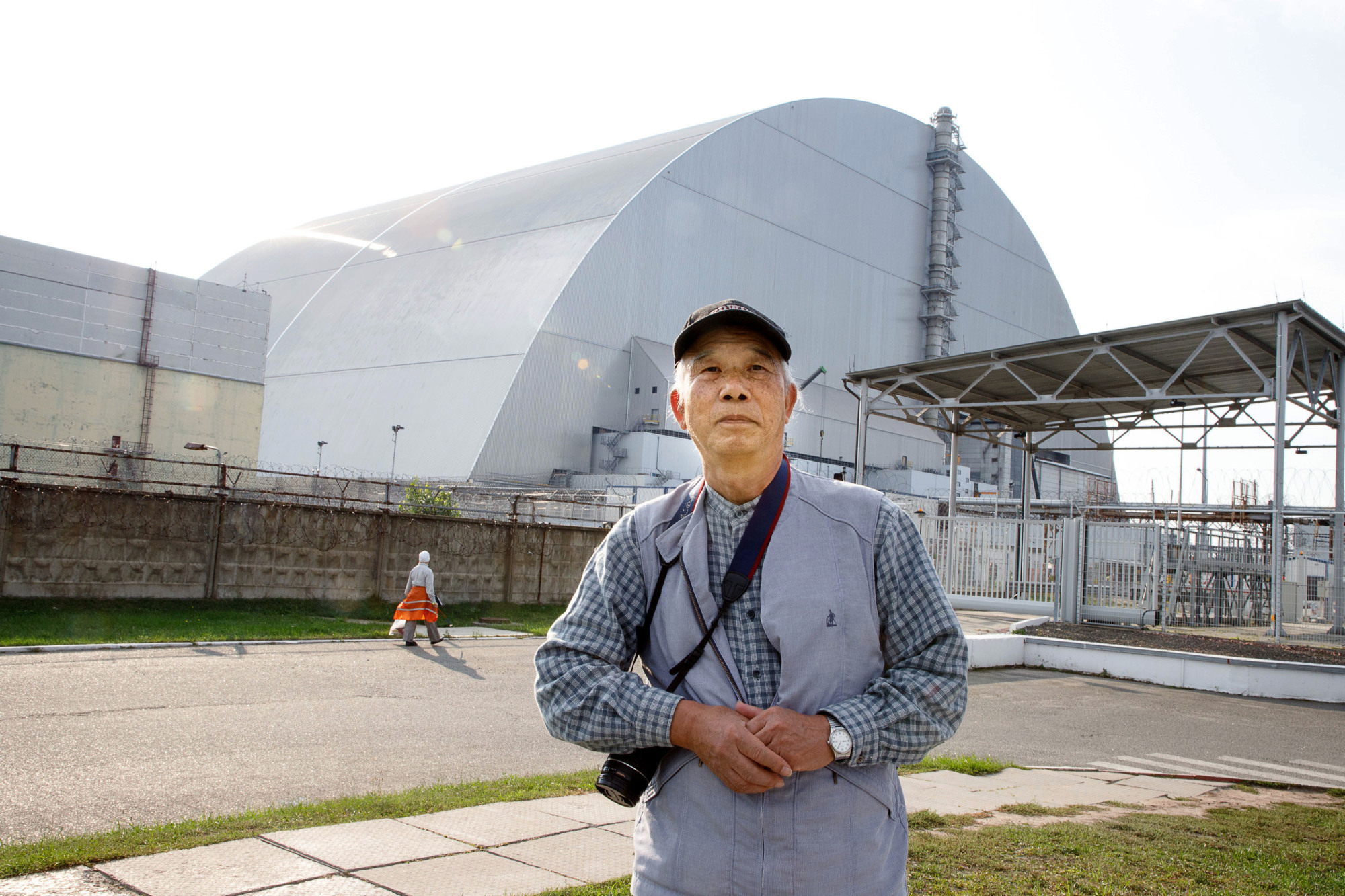 Nagasaki atomic bomb survivor Hiroshi Suenaga stands outside unit 4 of the Chernobyl nuclear power plant in Ukraine in September. | YOSHINO OISHI / VIA KYODO