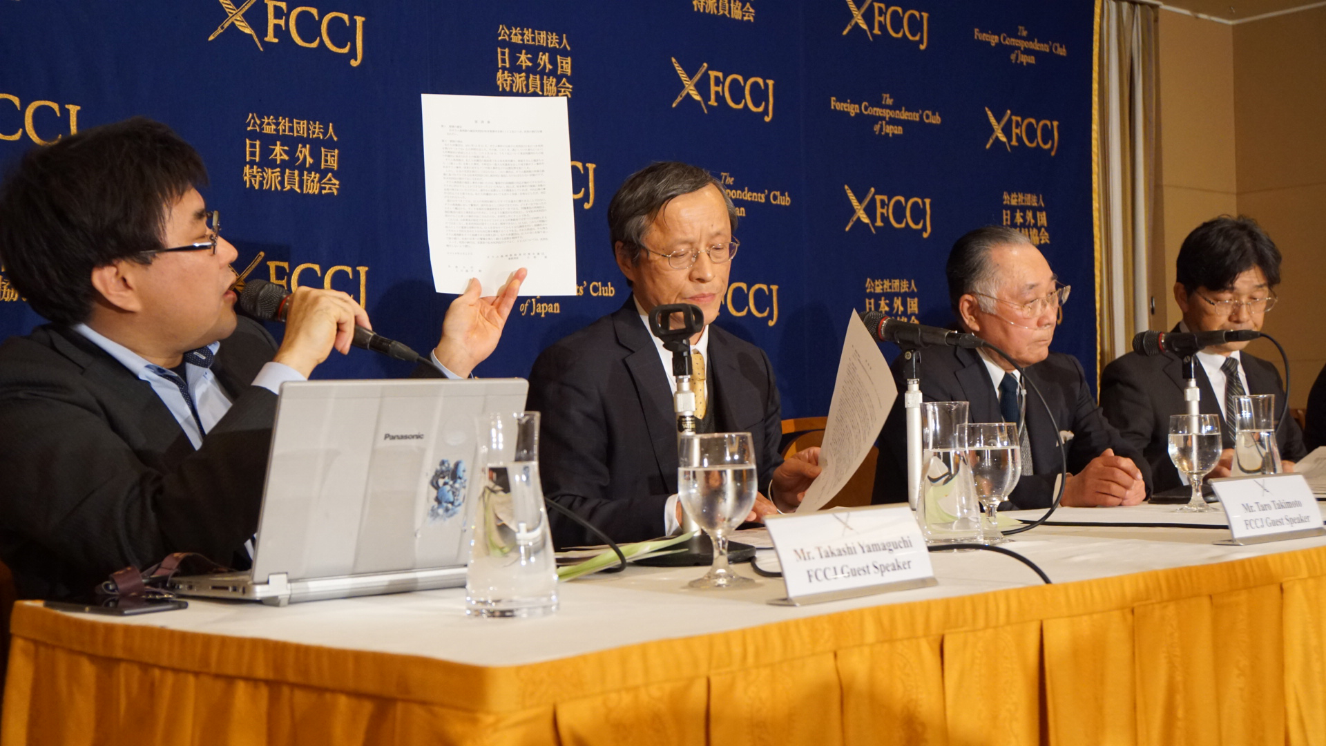 Takashi Yamaguchi, board member at the Japan Society for Cult Prevention and Recovery, holds up a petition sent to the Justice Ministry last week, requesting that the lives of the 12 former Aum members on death row be spared, at the Foreign Correspondents' Club of Japan Monday. | CHISATO TANAKA