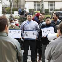 Mongolians living in Japan stage a rally in front of the head office of Shogakukan on Feb. 26 to protest a comic it published which included an image of Genghis Khan with a crude sketch of male genitalia across his forehead. | KYODO