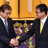 South Korea\'s National Intelligence Service chief Suh Hoon (left) shakes hands with Foreign Minister Taro Kono before their meeting in Tokyo Monday. | AP
