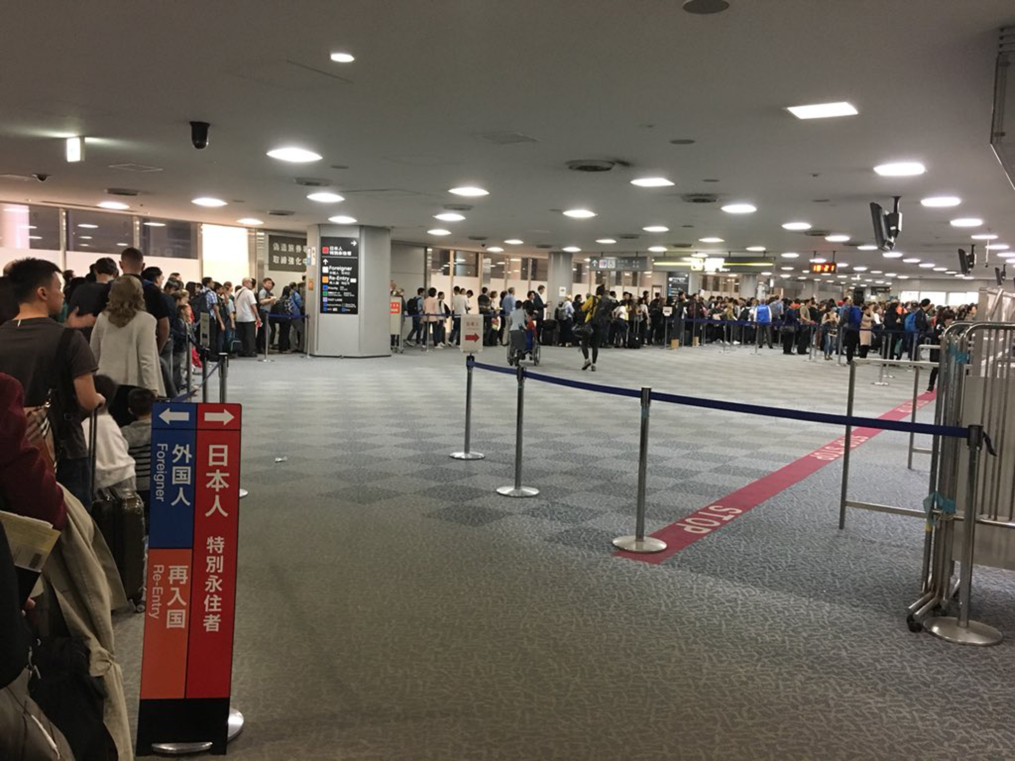 A massive line at Narita airport's border control area contrasts with the shorter one for Japanese in this photo by @younyaf on Twitter on Sunday. Some Twitter users claimed they waited for about three hours. | AP