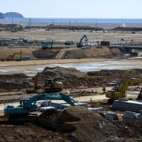 Work to elevate land devastated by tsunami in March 2011 progresses in Rikuzentakata in February. Millions of tons of soil brought in from higher ground is being used to raise the city\'s center by as much as 12 meters to mitigate future disasters. | SATOKO KAWASAKI