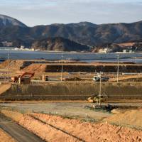 Work continues to elevate land in Rikuzentakata, Iwate Prefecture, in February. Millions of tons of soil brought in from higher ground is being used to raise the tsunami-ravaged city\'s former center by as much as 12 meters to mitigate future disasters. | SATOKO KAWASAKI