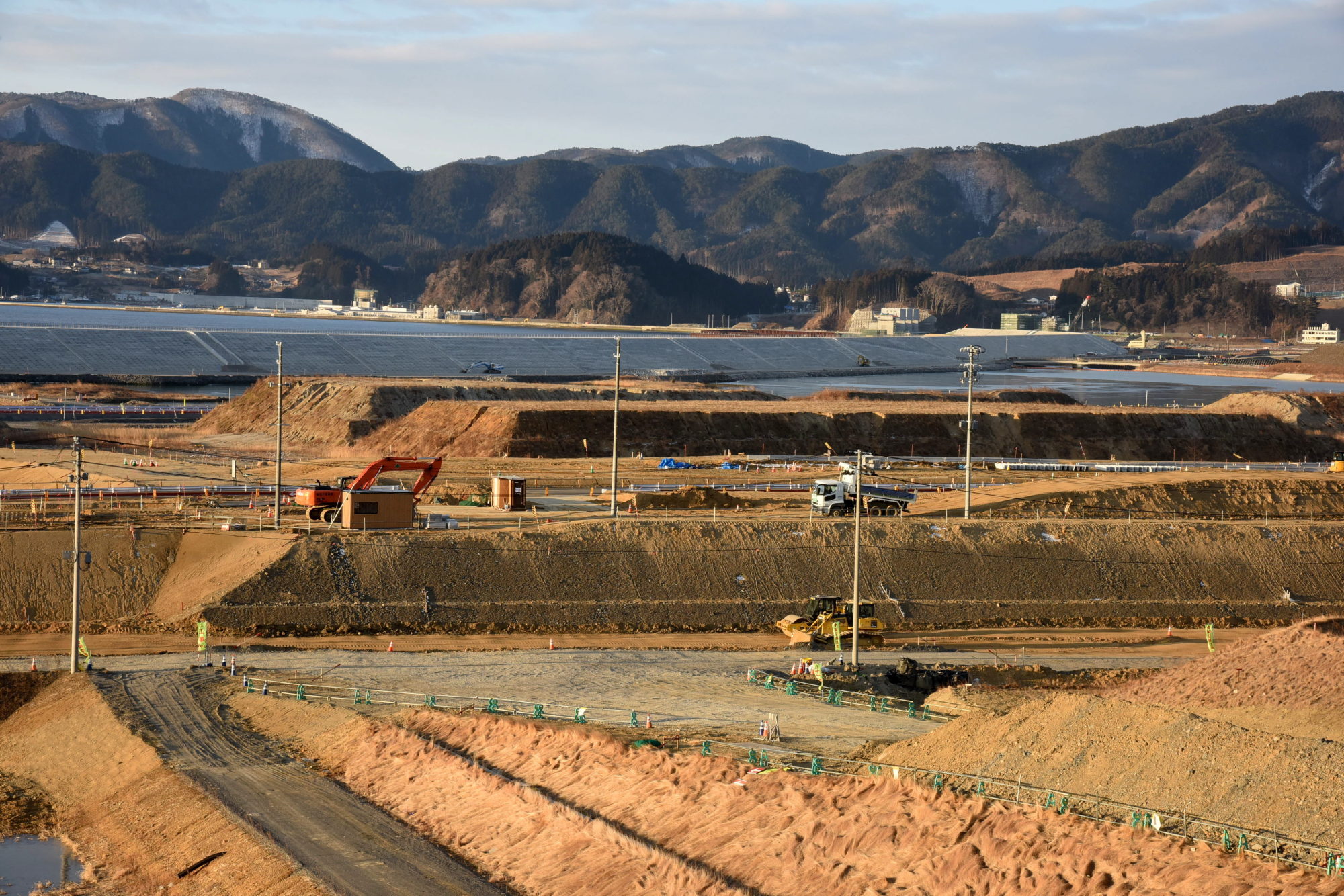 Work continues to elevate land in Rikuzentakata, Iwate Prefecture, in February. Millions of tons of soil brought in from higher ground is being used to raise the tsunami-ravaged city's former center by as much as 12 meters to mitigate future disasters. | SATOKO KAWASAKI