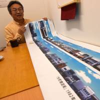 Seitoku Iwai, a 12th-generation shop owner in Rikuzentakata, Iwate Prefecture, shows an image of a shopping mall wiped out by the March 2011 tsunami, on Feb. 22. | SATOKO KAWASAKI