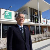 Takashi Ito, head of a business cooperative in Rikuzentakata, Iwate Prefecture, says he hopes the Abasse Takata shopping mall (background) built last year will become a place where what\'s left of his community can gather again. | SATOKO KAWASAKI