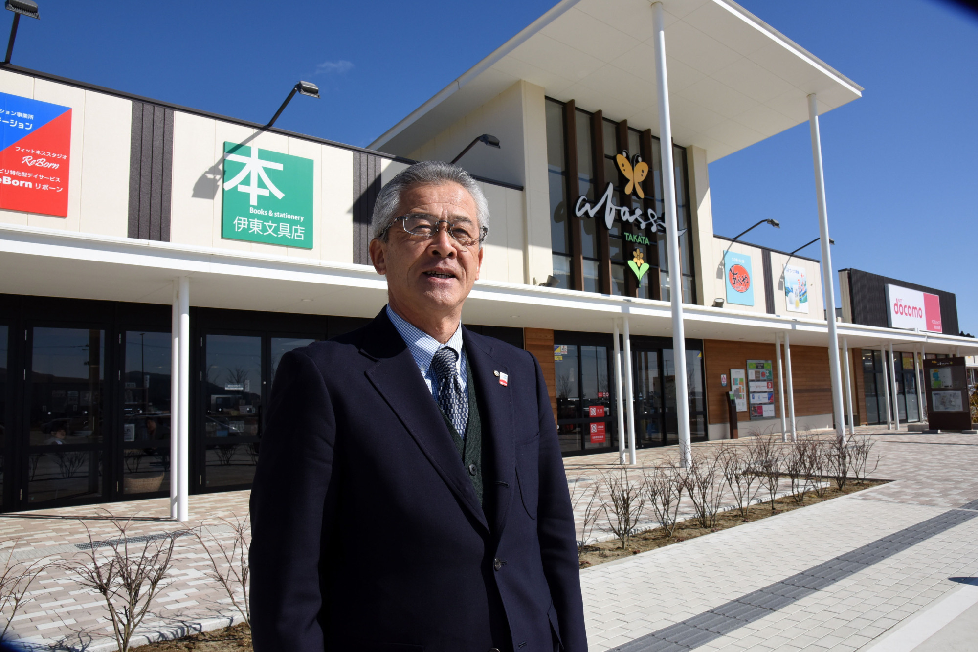 Takashi Ito, head of a business cooperative in Rikuzentakata, Iwate Prefecture, says he hopes the Abasse Takata shopping mall (background) built last year will become a place where what's left of his community can gather again. | SATOKO KAWASAKI