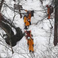 Rescuers work toward 13 mountain climbers trapped in the Okutama area of western Tokyo on Thursday. | KYODO
