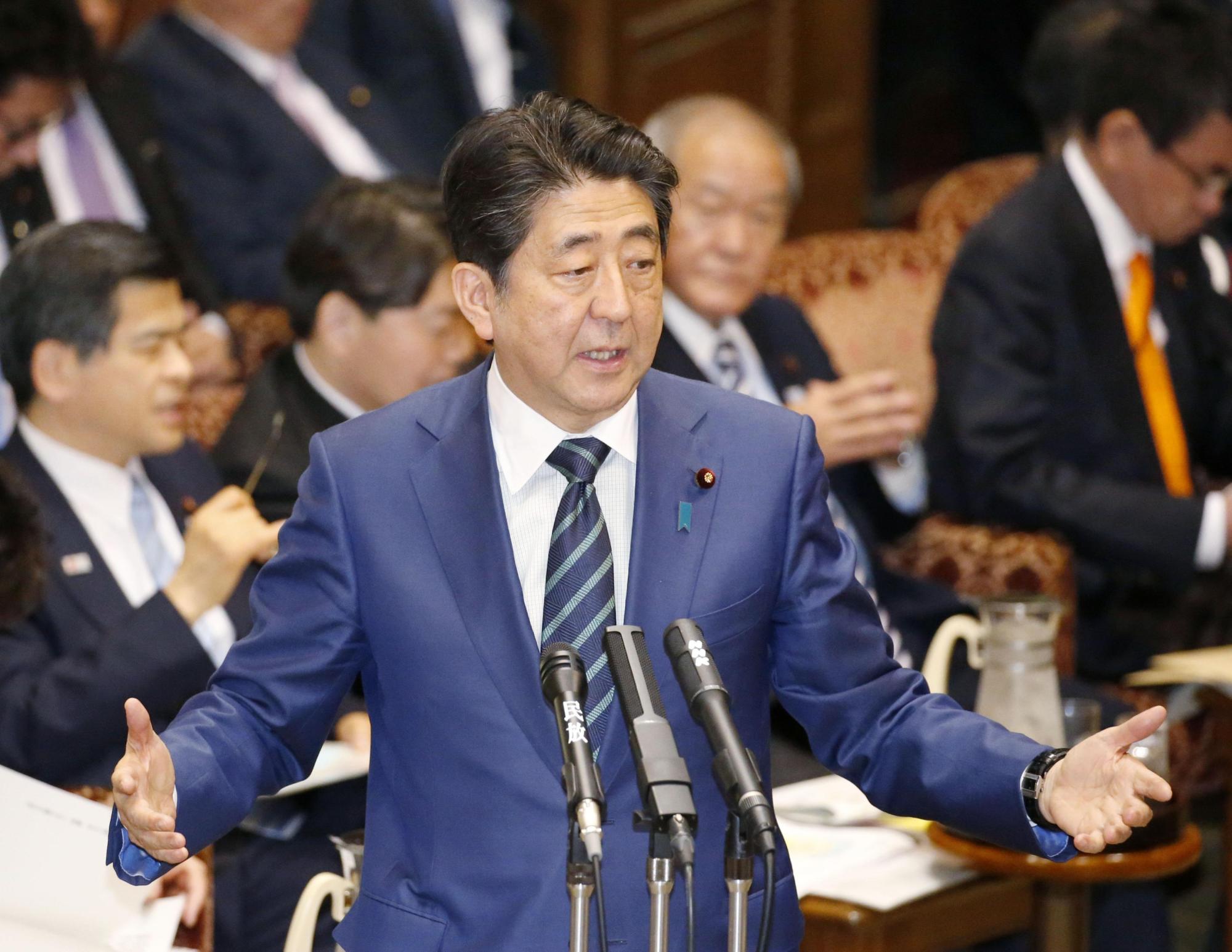 Prime Minister Shinzo Abe speaks at the  Upper House Budget Committee on March 1, where he promised the government would look again at the impact of the discretionary work system on people's work hours. | KYODO