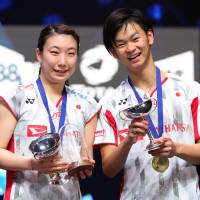 Arisa Higashino (left) and Yuta Watanabe celebrate with their trophies after winning the All England Open mixed doubles title on Sunday in Birmingham, England. | ACTION IMAGES VIA REUTERS