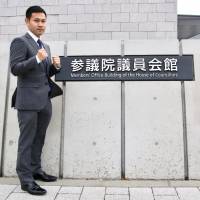 Former minimumweight world champion Katsunari Takayama poses for photos in front the Members\' Office Building of the House of Councillors after his meeting with politician Seiko Hashimoto on Wednesday. | KAZ NAGATSUKA