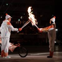 Athletes pass the Paralympics torch during the opening ceremony for the Pyeongchang Winter Paralympics at Olympic Stadium in Pyeongchang, South Korea, on Friday. | REUTERS