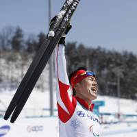 Yoshihiro Nitta exults after winning the gold medal in the 10-km classic standing cross-country race at the Pyeongchang Paralympics on Saturday. | KYODO
