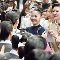Students of Takarazuka Music Schools congratulate those who passed an entrance exam in Takarazuka, Hyogo Prefecture on Thursday. This year, 965 women took the test but only 40 will be able to study in the school that trains new talent for the famous all-woman Takarazuka Revue. | KYODO
