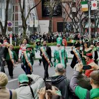 People dressed in green walk along Omotesando Dori Avenue in Tokyo during the annual St. Patrick\'s Day Parade on Sunday. About 1,500 people participated in the event and an estimated 30,000 watched. | YOSHIAKI MIURA