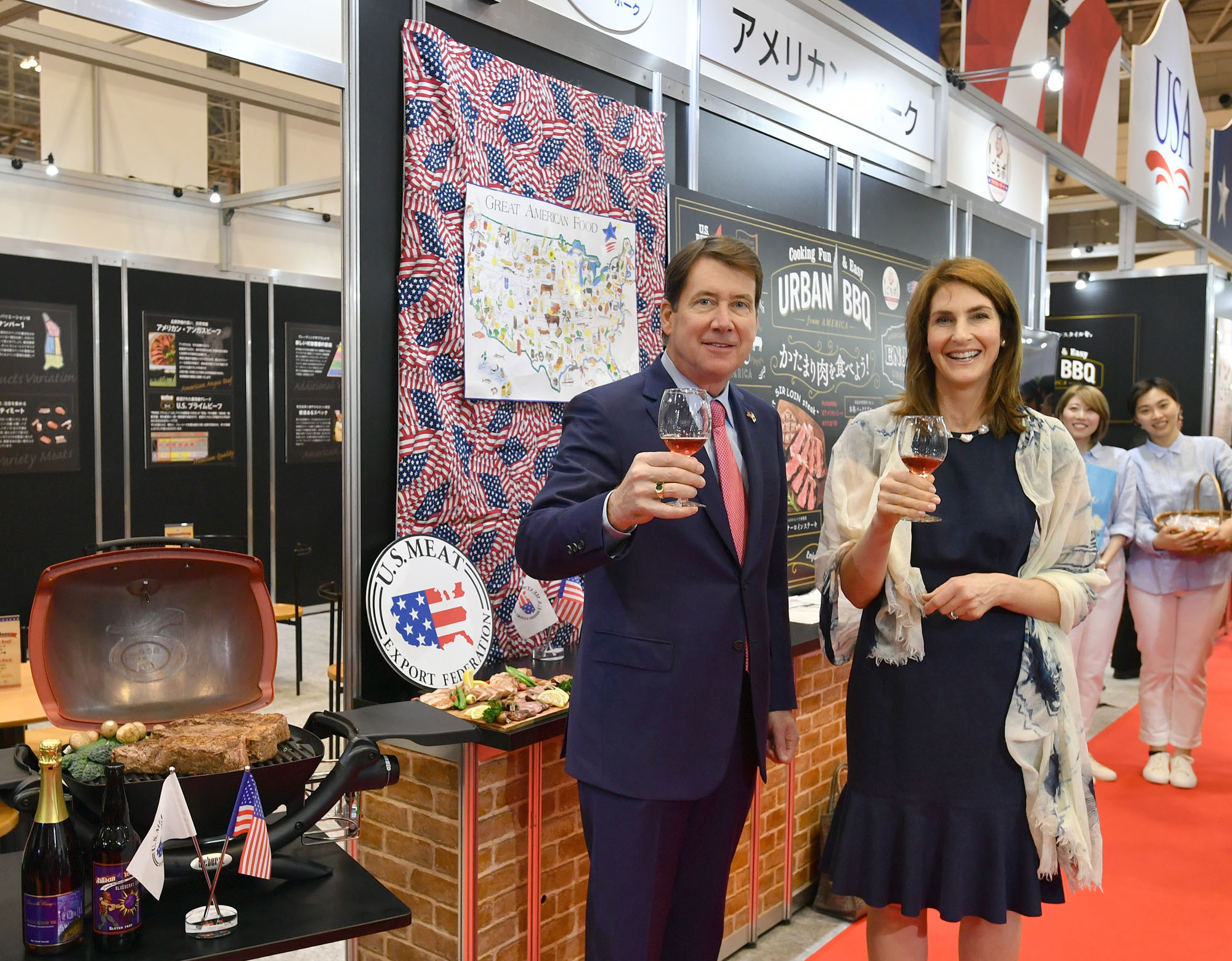 U.S. Ambassador to Japan William Hagerty (left) and his wife, Chrissy Hagerty, pose at the U.S. Pavilion of the  Foodex Japan 2018 food trade show Tuesday at Makuhari Messe in Chiba Prefecture. The pavilion features 53 U.S. companies and organizations such as the U.S. Meat Export Federation and includes booths for visitors to sample American products. | YOSHIAKI MIURA