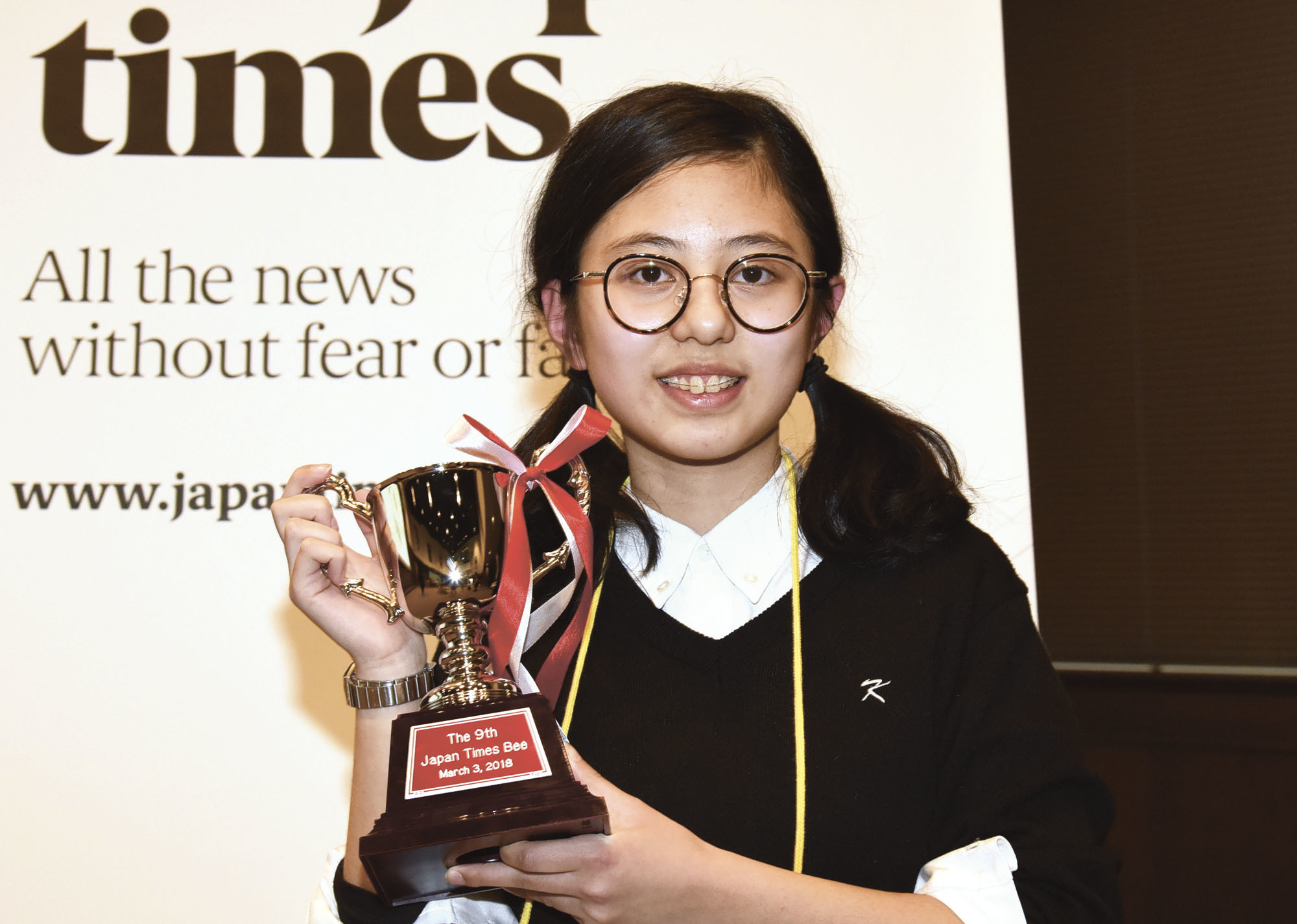 Hanna Yoshida from K. International School Tokyo poses with her trophy on Saturday after winning the ninth Japan Times Bee at the newspaper's headquarters in Tokyo. Yoshida correctly spelled insubordinate to secure the right to represent Japan at the Scripps National Spelling Bee in Washington in May. | SATOKO KAWASAKI