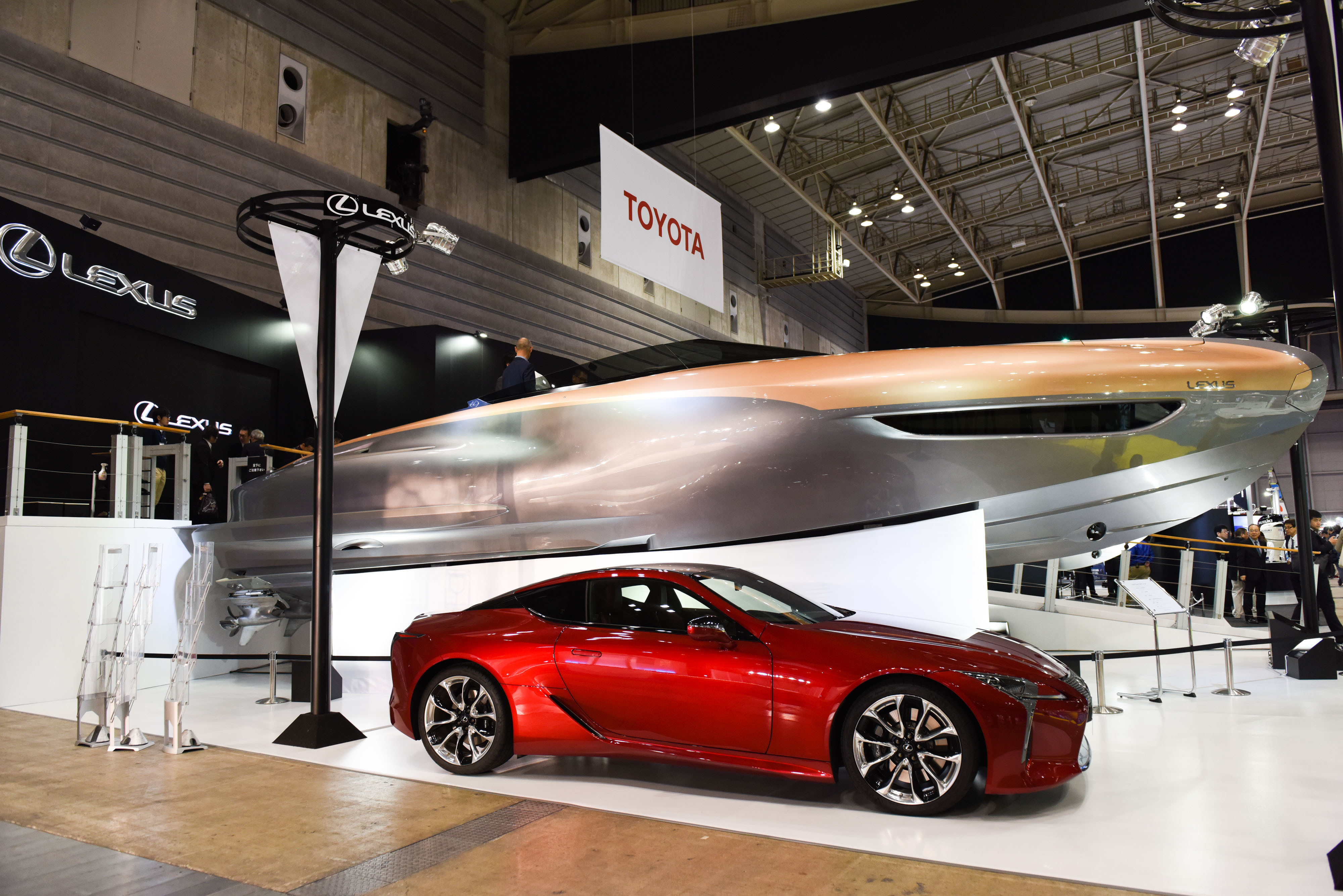 Toyota Motor Corp.'s Lexus Sport Yacht Concept looms over a Lexus LC 500 at the Japan International Boat Show in Yokohama on March 8. Toyota's premium brand plans to start selling a 65-foot (20-meter) ultra-luxury yacht in the United States in the second half of 2019 as part of its strategy to sell more cars and catch up to its rivals. | BLOOMBERG