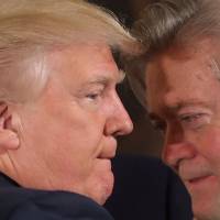 U.S. President Donald Trump talks to senior staff Steve Bannon during a swearing-in ceremony for senior staff at the White House in Washington in January 2017. | REUTERS