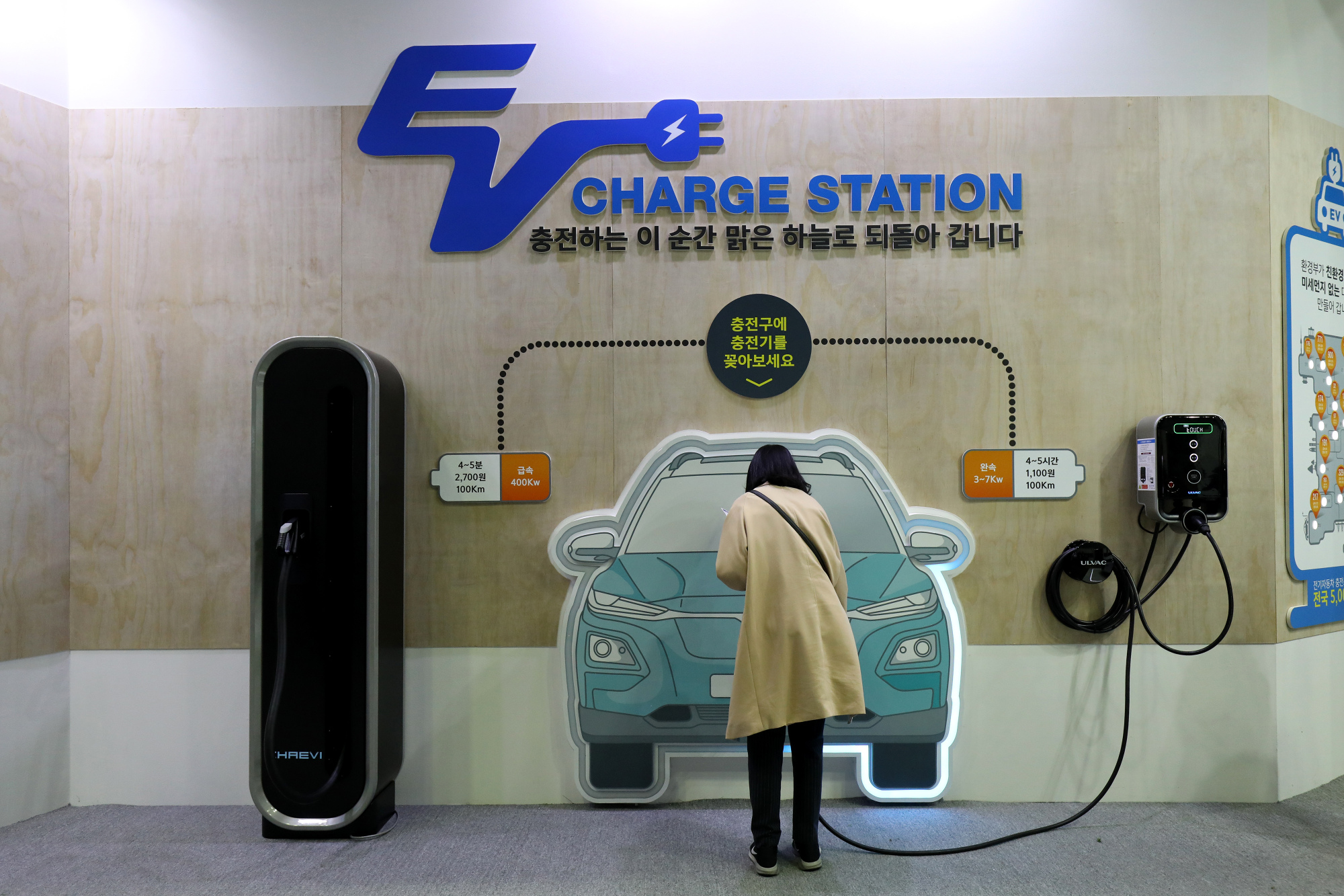 An attendee looks at a charging cable at the EV Trend Korea 2018 exhibition in Seoul on April 12. | BLOOMBERG