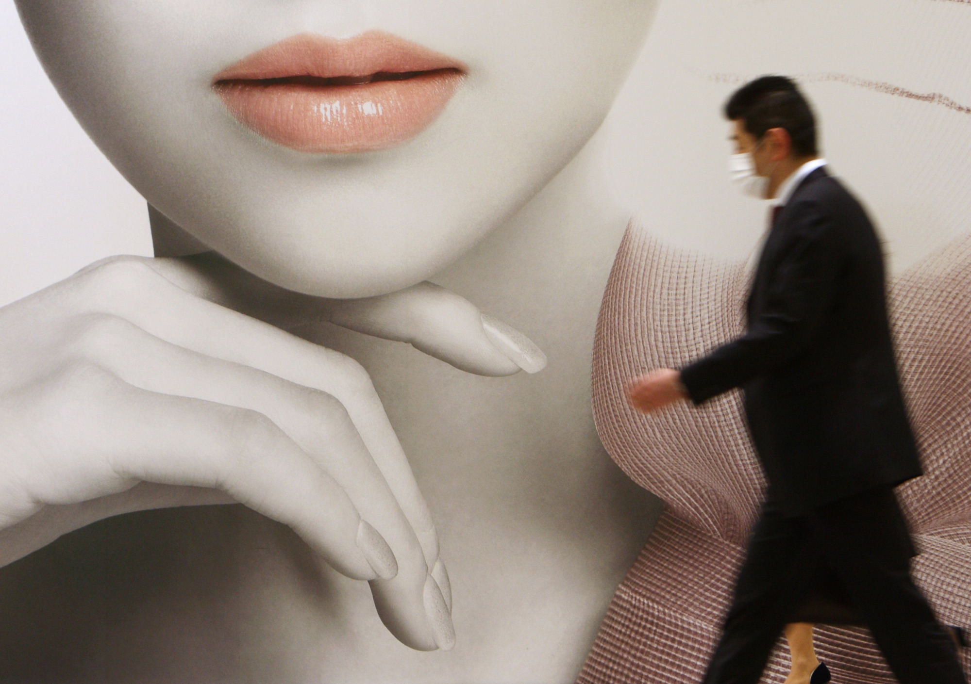 A man walks past an advertisement for Shiseido Co. in Tokyo. | BLOOMBERG